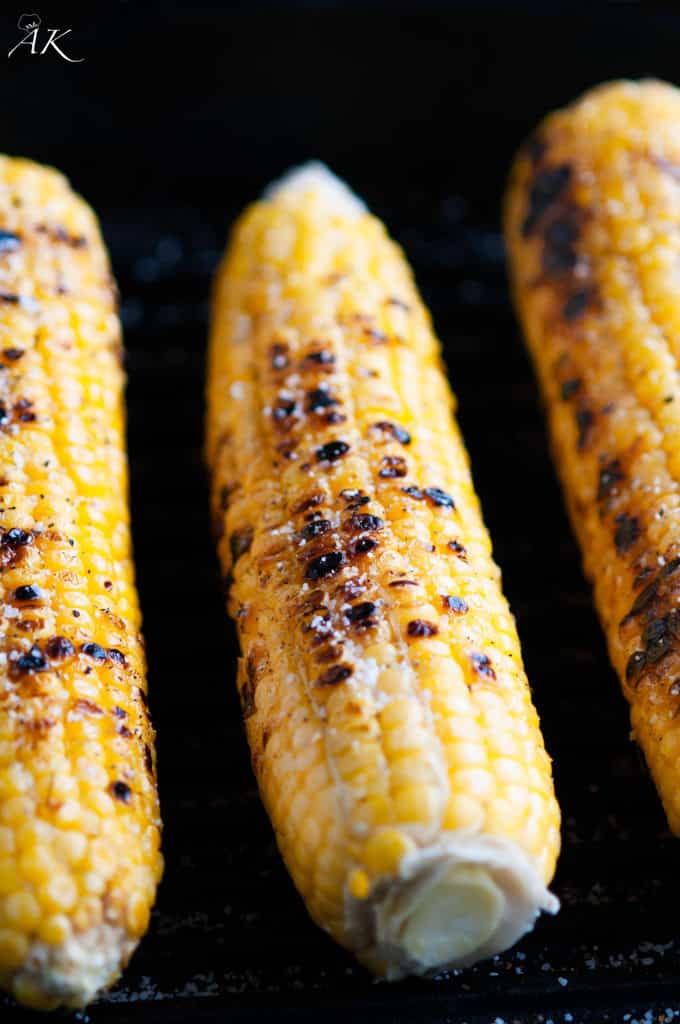 Grilled corn on the cob in cast iron skillet close up