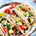 Grilled yellow corn and black bean tacos on festive plate