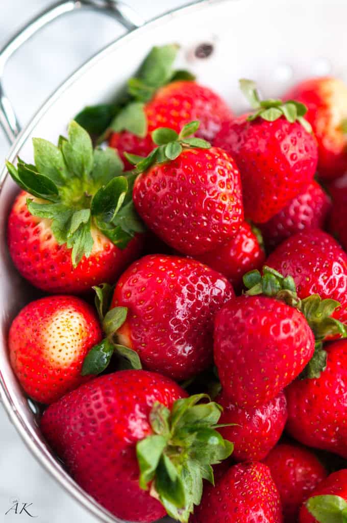 fresh strawberries in a white strainer