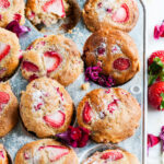 Easy Strawberry Rhubarb Muffins in gray baking tin with flowers on white marble