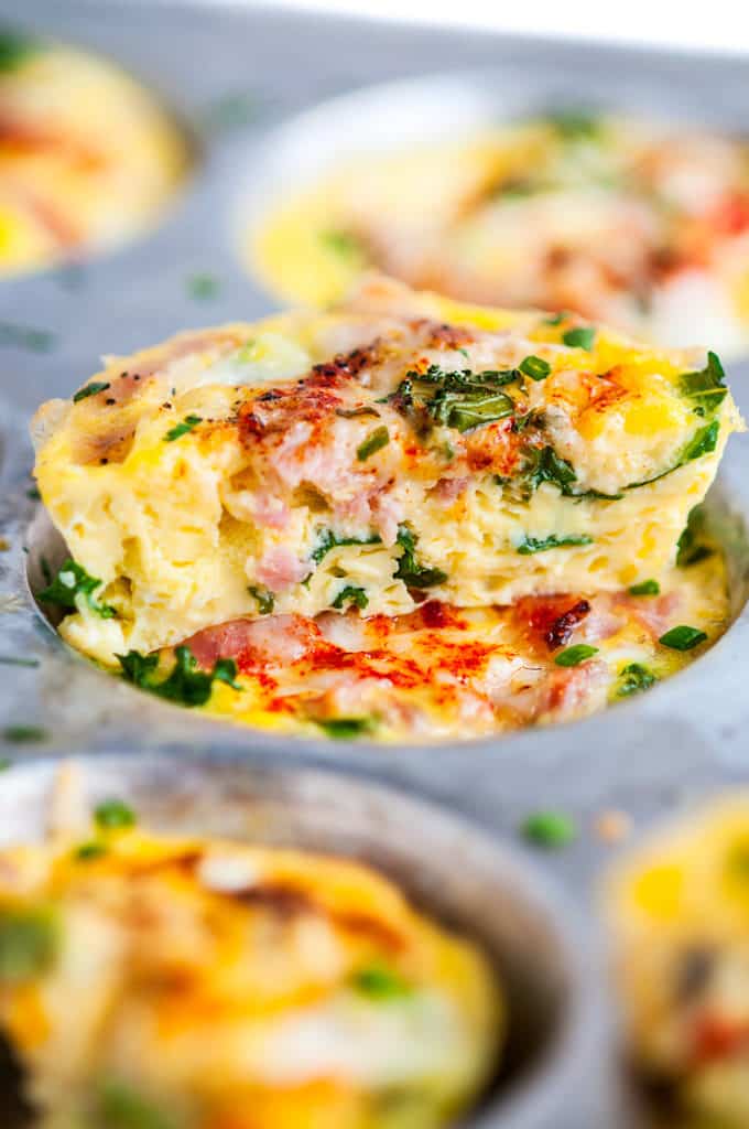 Close up of make ahead healthy breakfast egg cups with ham and kale in muffin tray