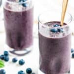 Blueberry Spinach Smoothie in glasses with gold spoons