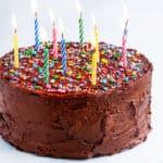 Devil's Food Cake with Chocolate Buttercream Frosting with lit birthday candles