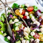 Greek Salad with Homemade Vinaigrette with towel adn salad tongs