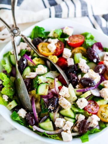 Greek Salad with Homemade Vinaigrette with towel adn salad tongs
