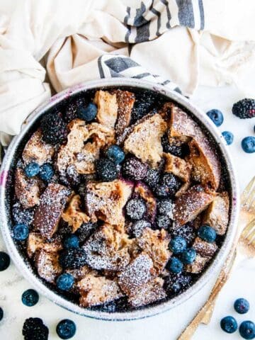 Instant Pot Cinnamon Berry French Toast Casserole in a gray pan with gold forks and towel