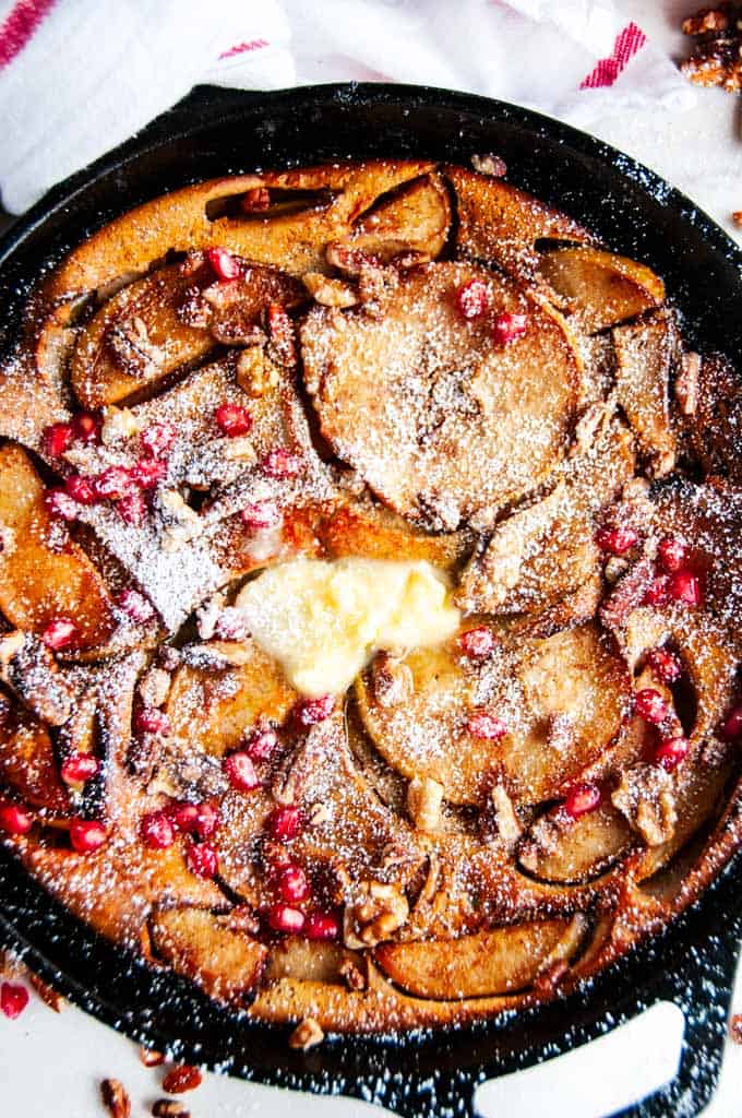 Chai Spice Apple Dutch Baby with Honey Butter in cast iron Lodge skillet and white towel