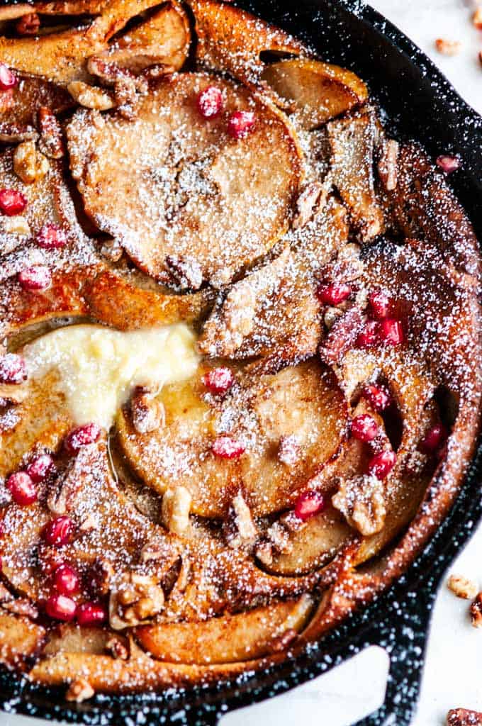 Chai Spice Apple Dutch Baby with Honey Butter in cast iron Lodge skillet and white towel
