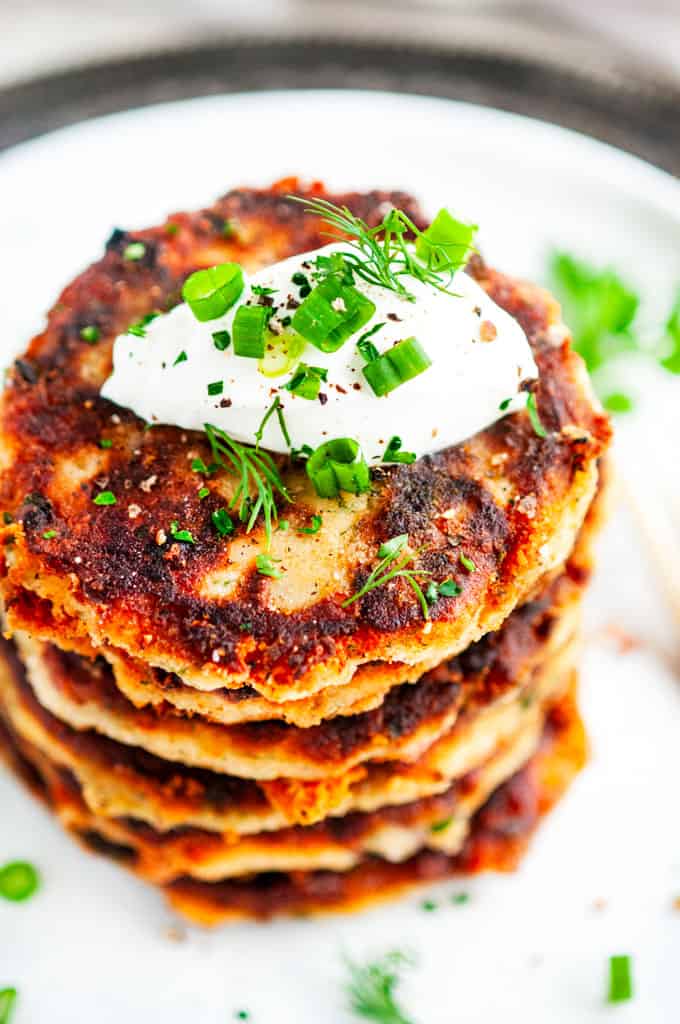 Cheesy Garlic Leftover Mashed Potato Pancakes stack with sour cream top view