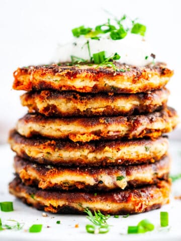 Cheesy Garlic Leftover Mashed Potato Pancakes stack with sour cream stack center side view