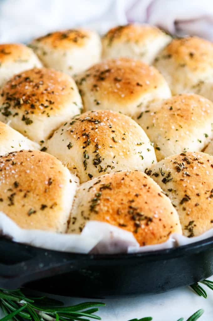 Rosemary Garlic Dinner Rolls in lodge cast iron skillet with parchment paper