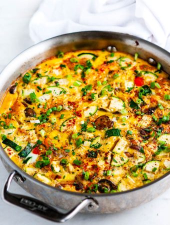 Loaded Veggie Frittata in all clad skillet on white marble
