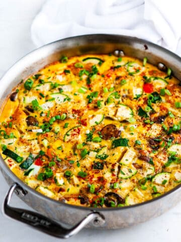Loaded Veggie Frittata in all clad skillet on white marble