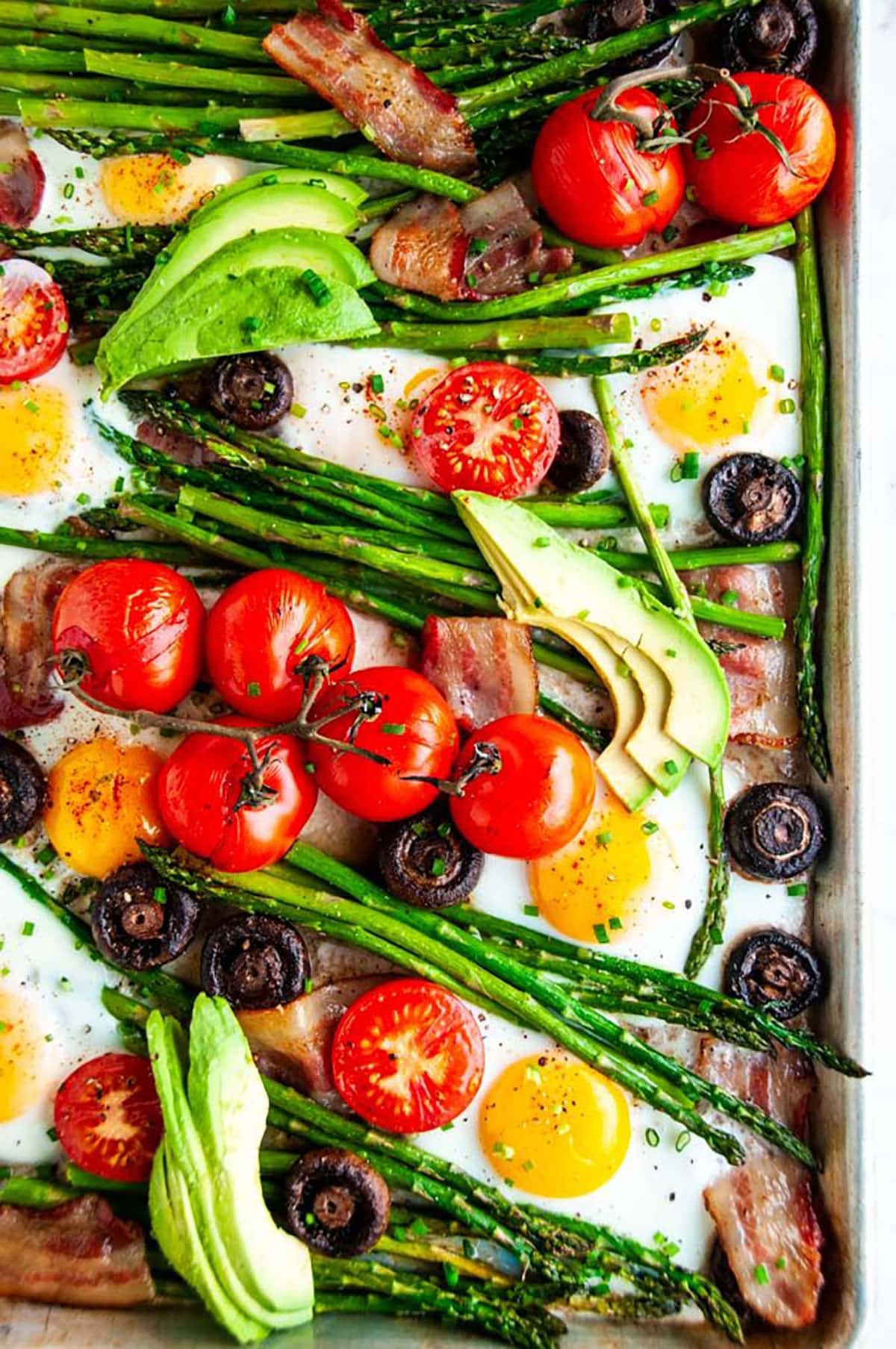 Sheet pan breakfast bake with tomatoes, eggs, asparagus, mushrooms, bacon and avocado
