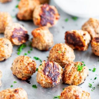 Baked Turkey Meatballs on sheet pan with parchment paper and marinara dipping sauce