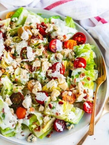 Chopped wedge salad on gray plate with gold fork
