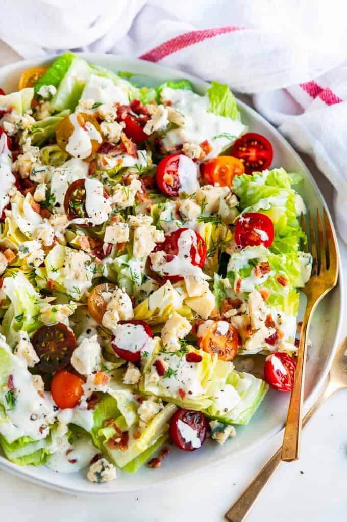 Chopped wedge salad on gray plate with gold fork