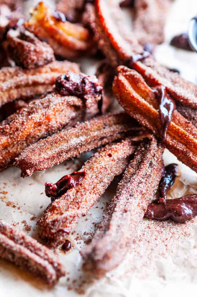 Homemade Churros with Mexican Dipping Sauce on brown parchment paper
