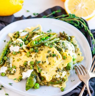 Spring Pea Asparagus Ricotta Ravioli on gray plate with lemons and gold fork