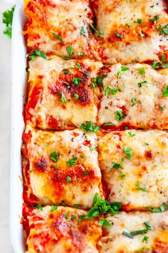Garden Vegetable Lasagna in red and white casserole dish on white marble