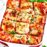 Garden Vegetable Lasagna in red and white casserole dish on white marble