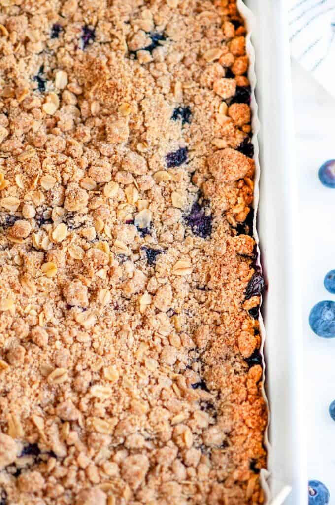 Blueberry crumble bars in white baking dish on white marble
