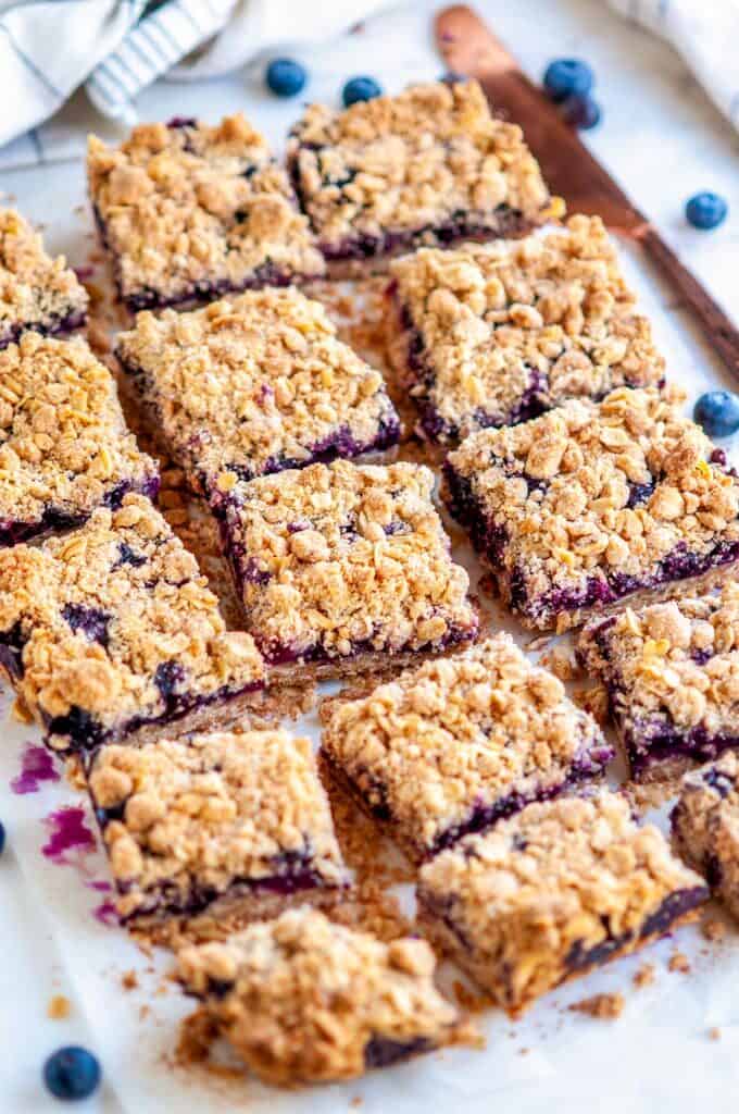 Blueberry crumble bars sliced on white parchment paper