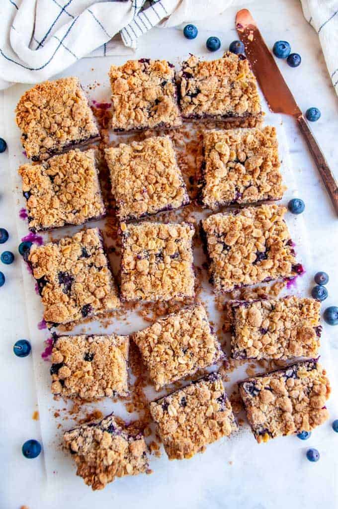 Blueberry crumble bars sliced on white parchment paper
