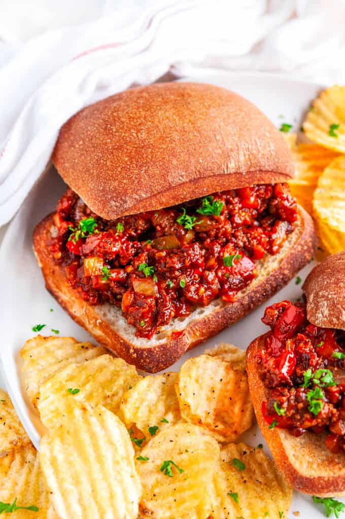 Best Ever Sloppy Joes with chips and tea towel on white plate and marble 