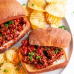 Best Ever Sloppy Joes with chips and tea towel on white plate and marble