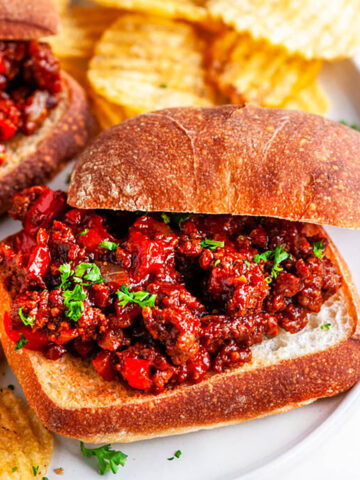Best Ever Sloppy Joes with chips on white plate and marble