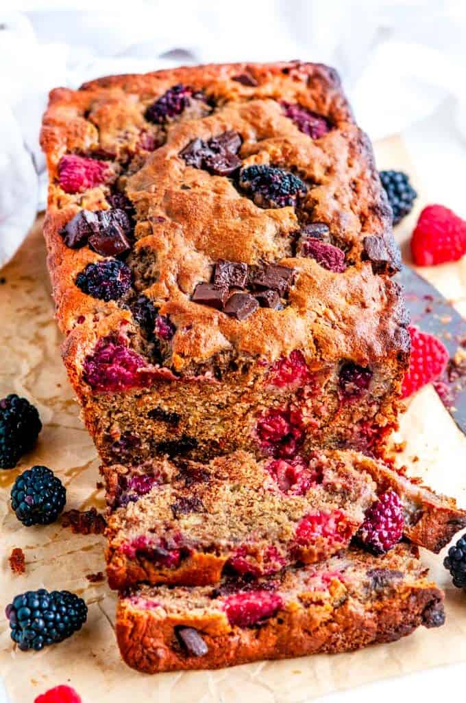 Chocolate Chunk Berry Banana Bread with knife on parchment paper