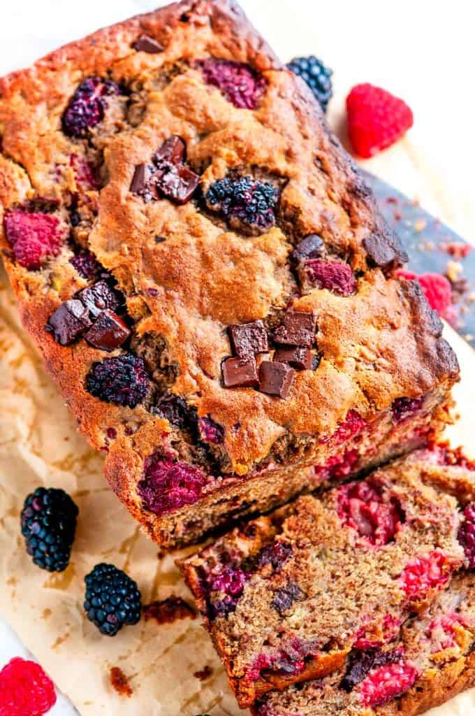 Chocolate Chunk Berry Banana Bread with knife on parchment paper