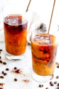Cold Brew Coffee in tall glasses on white marble with tea towel
