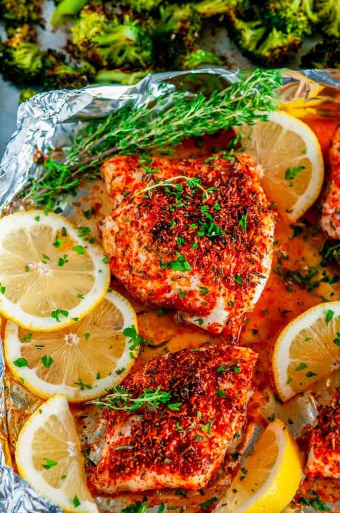 Sheet Pan Paprika Parmesan Cod with Broccoli in foil with lemons and herbs close up