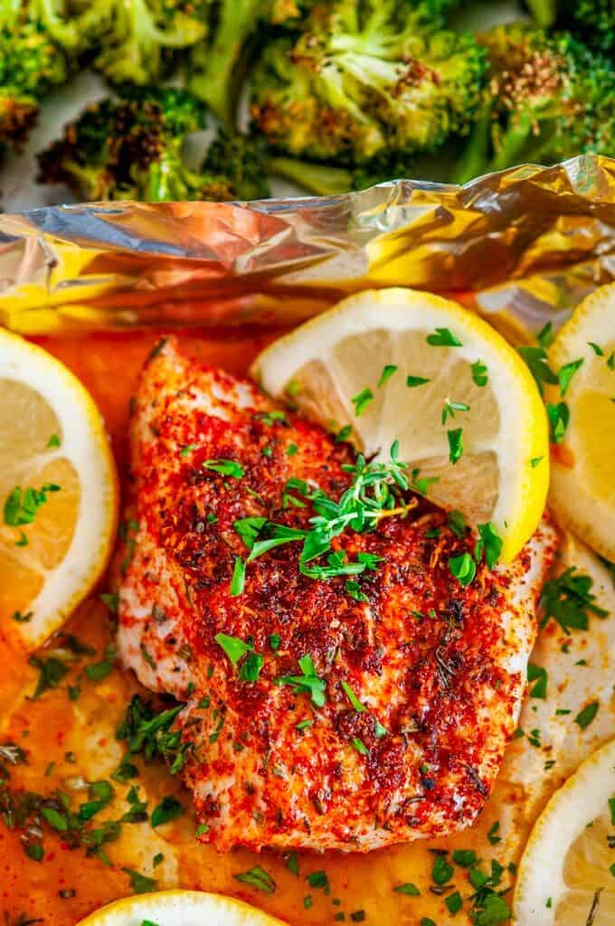 Sheet Pan Paprika Parmesan Cod with Broccoli in foil with lemons and herbs close up