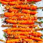 Garlic Parmesan Roasted Carrots with fresh parsley on parchment paper