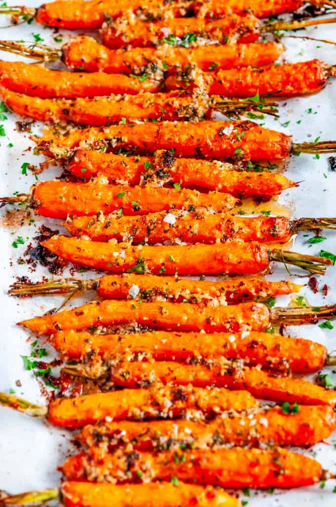 Garlic Parmesan Roasted Carrots with fresh parsley on parchment paper