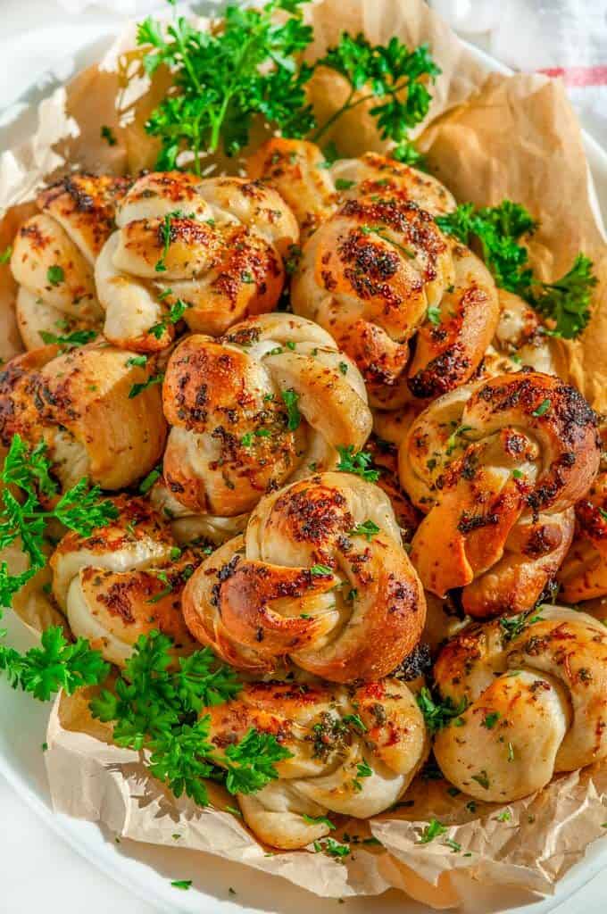 Herb Garlic Parmesan Knots with parsley on white platter