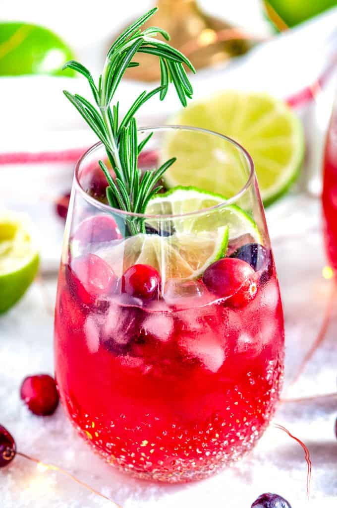 Yuletide Cranberry Moscow Mule with rosemary and limes on white marble close up