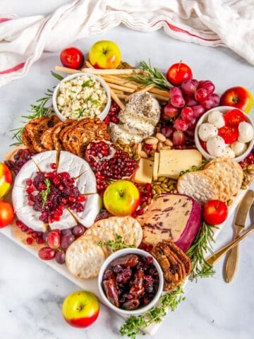 Festive Winter Cheese Board on marble with gold knife and spoon