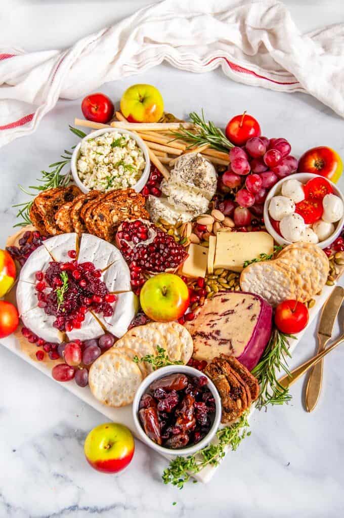 Festive Winter Cheese Board on marble with gold knife and spoon