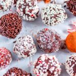 Homemade Chocolate Truffles with sprinkles, candy canes and cocoa on parchment paper