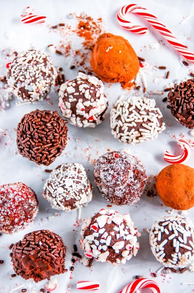 Homemade Chocolate Truffles with sprinkles, candy canes and cocoa on parchment paper
