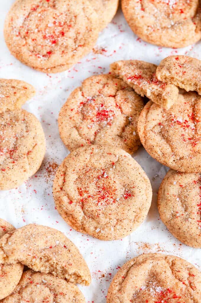 Soft Chewy Snickerdoodles on white parchment with red sanding sugar close up