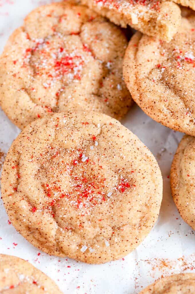 Soft Chewy Snickerdoodles on white parchment with red sanding sugar close up