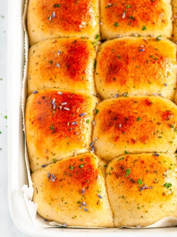 Honey Lavender Herb Dinner Rolls in white baking dish with parchment baked close up