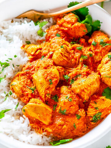 Instant Pot Chicken Tikka Masala in white bowl with basmati rice, cilantro and gold fork