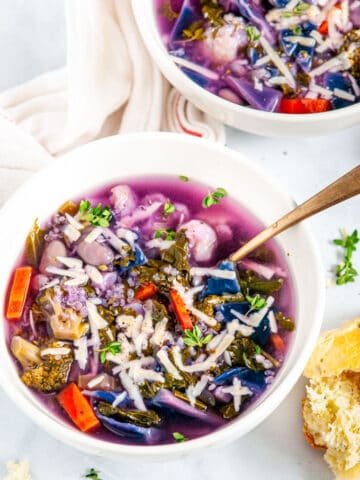 White Bean Purple Cabbage Soup with gold spoons in white bowls