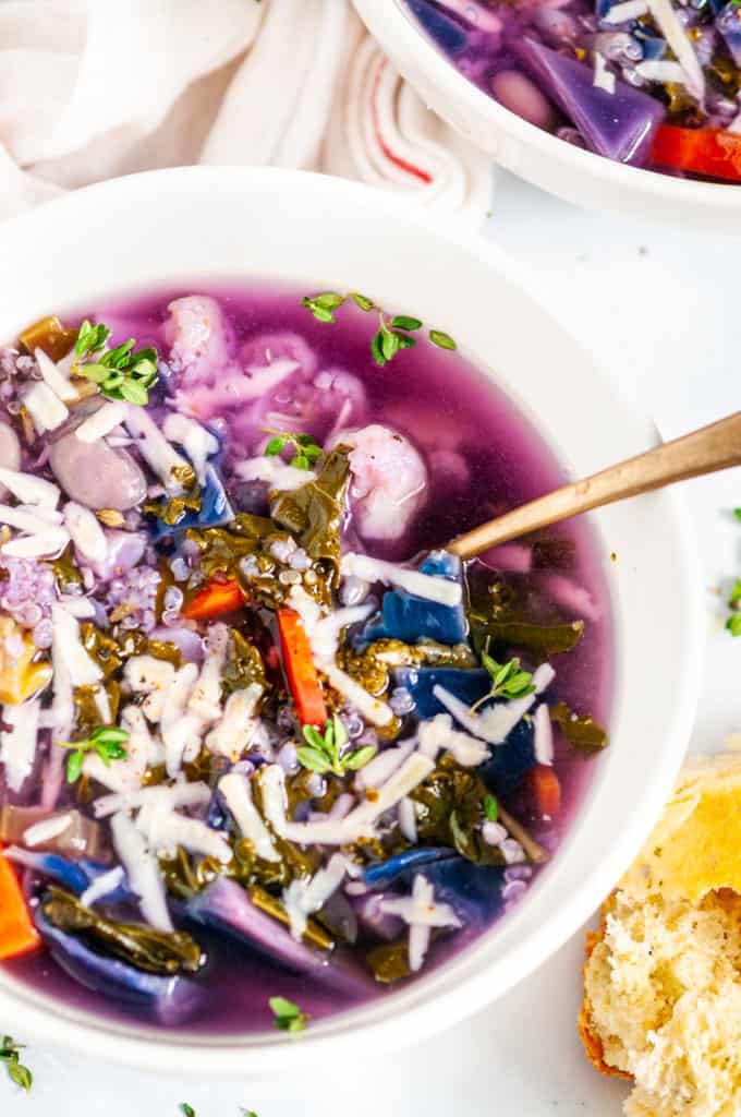 White Bean Purple Cabbage Soup with gold spoon in white bowl close up